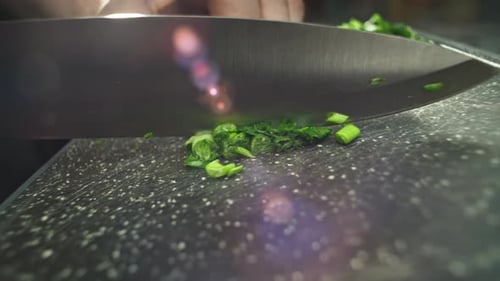 Slow Motion Closeup Video of Slicing Green Onions on a Cutting Board