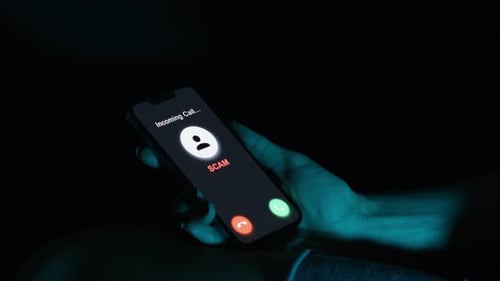Hand Holding Phone with Scam Incoming Call