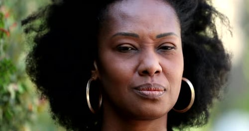 Thoughtful Woman with Natural Hair Smiling Outdoors