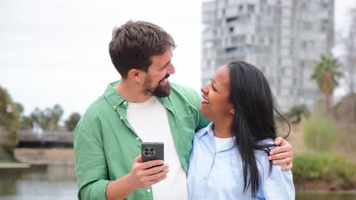 Affectionate Couple Enjoying Mobile Phone in Urban Park Setting