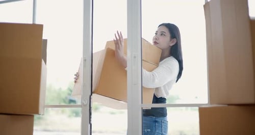 Young Woman Carrying Boxes into New Home