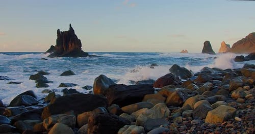 Beautiful natural sea landscape with rocky volcanic beach. Rolling big ocean waves to the stone shor