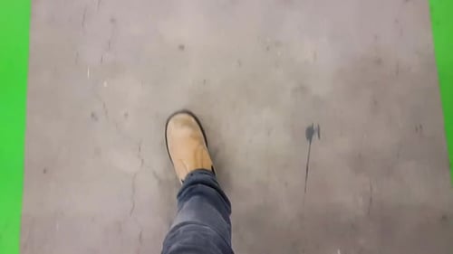 Walking with safety boots on a specially designed walking path on a concrete factory shop floor. Rea