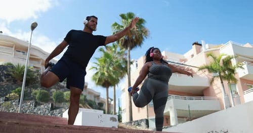 Man and Woman Stretching Outside in Tropical Setting