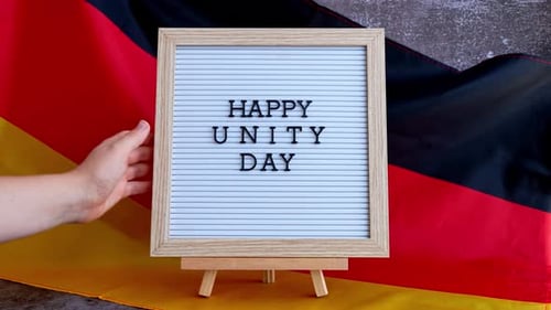 Brieftafel mit Aufschrift HAPPY UNITY DAY Nationales Symbol von Deutschland Deutsche Welle, seidige Flagge