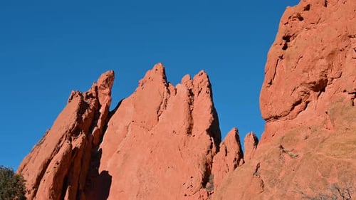 Dramatisch Drohnenblick auf die zerklüfteten roten Sandsteinformationen im Garden of the Gods vor leuchtendem Blau