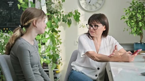 Woman Talks with Teen Girl at Home