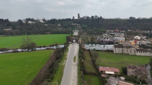 Drone descent over Ponte Visconteo road crossing Mincio River in Valeggio sul Mincio, Italy