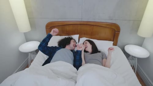 Joyful Couple Laughing Together Lying in Bed