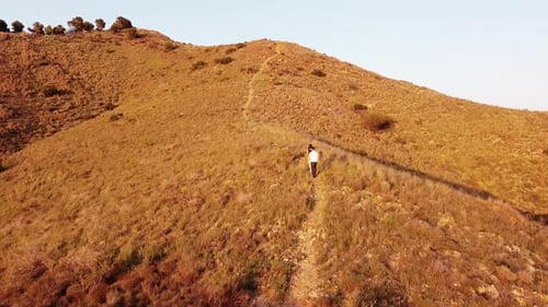 young couple hiking through mountains at sunset drone view point. Dron aerial view at sunset in Mur