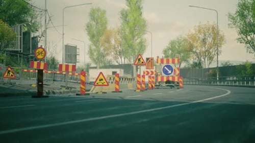 Road Construction in Urban Area with Warning Signs and Barriers in Fall
