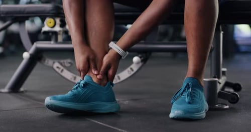 Fitness, hands and person with ankle pain in gym from injury, muscle tension and inflammation