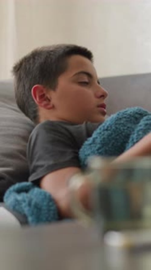 Teenage Boy Lying on Couch Feeling Sick