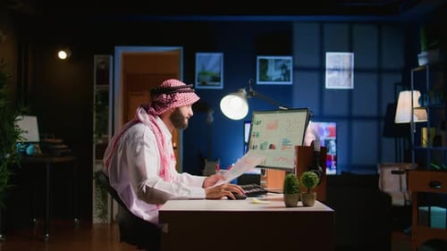 Man Working at Desk with Computer and Documents