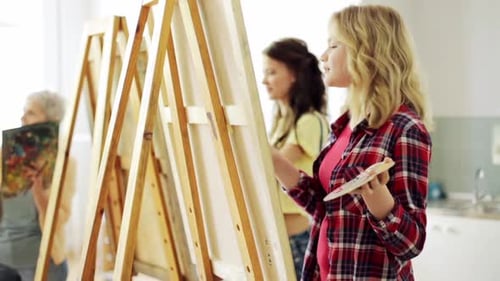 Art School Creativity and People Concept - Group of Students with Easels