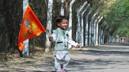 kid walking holy saffron flag with lord rama idol at day from flat angle