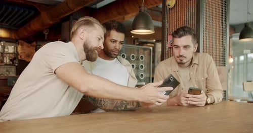 Men Friends Sitting and Relax at Bar with Smartphones Talking and Smile
