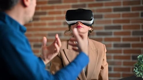 Woman using a Virtual Reality headset in an office while explains and gesticulates