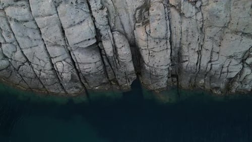 Aerial View of Rocky Coastline Meets Turquoise Ocean