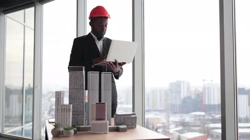Chief Architect African Man in Business Suit and Protective Helmet Working with City Buildings Mode