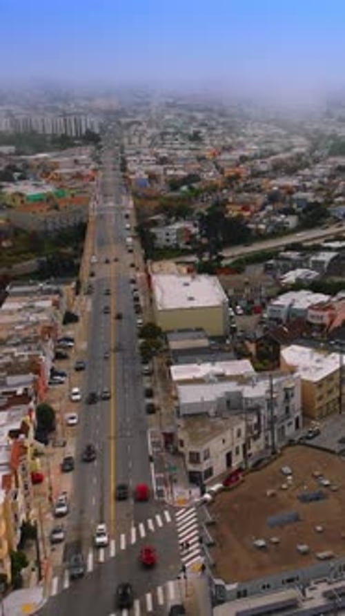 Lively traffic on the roads of beautiful city. San Francisco panorama getting lost in the thick fog