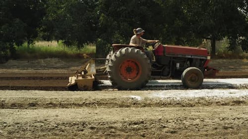 Tractor with special attachment preparing and tilling the field, farm equipment in slow motion
