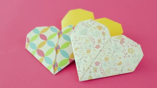Paper Origami Hearts on Pink Background