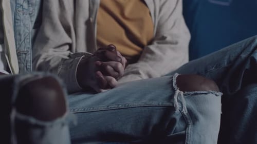 Unrecognizable Couple Holding Hands In Cinema