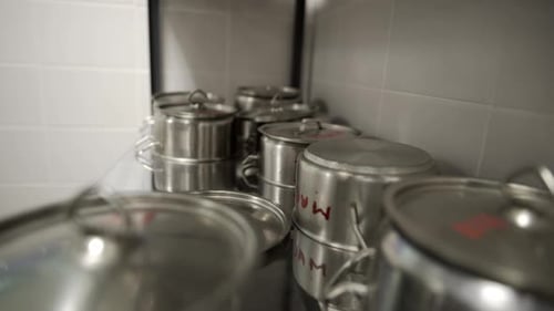 Stainless Pots with Lids on Racks in School Canteen Kitchen