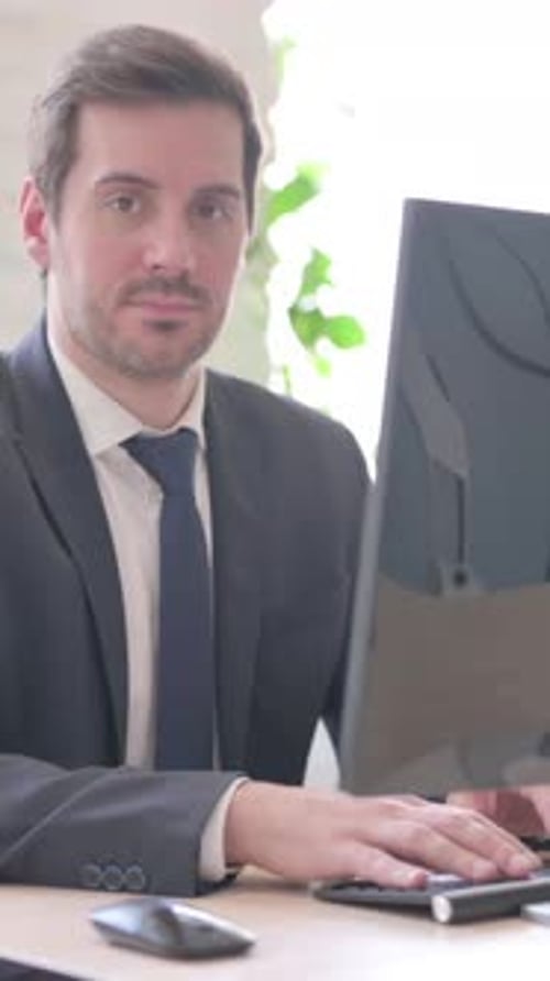 Professional Man Typing at a Computer in Office