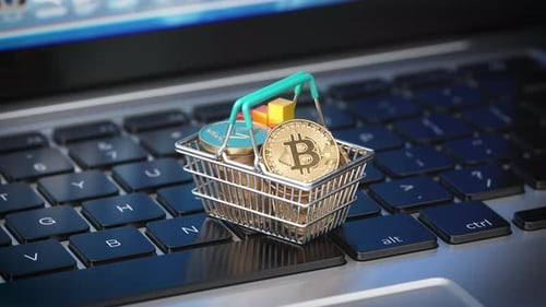 Bitcoin Coins in a Shopping Basket and Growing Graph on Laptop Keyboard