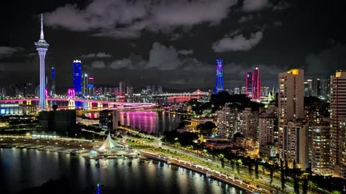 Cool-toned twilight view of skyline from rooftop, city lights reflect in water