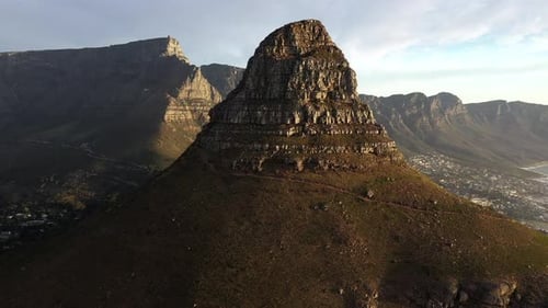 Dramatic Fly-Over Cinematic Shot of Lion's Head Peak with Table Mountainl During Golden Hour Sunset