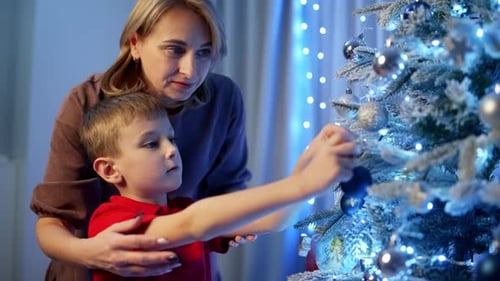 Mother and Son Decorating Christmas Tree at Home
