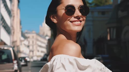 Smiling Woman Walking City Street on Sunny Day