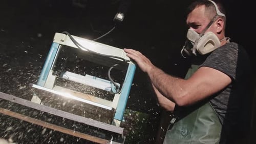 A Man Works with a Thickness Planer