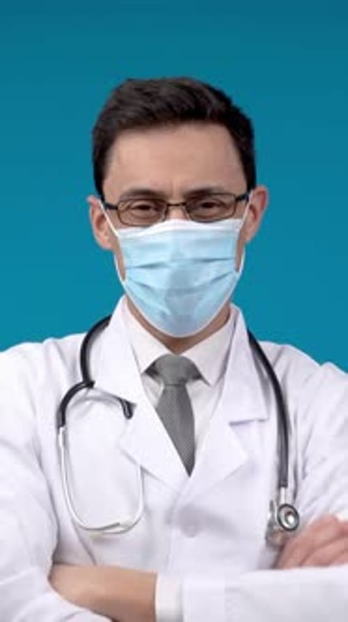 Male Doctor in Mask Looking at Camera in Studio