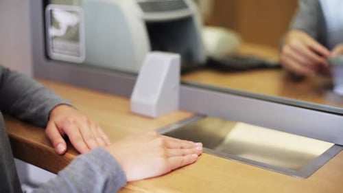 Empleado contando dólares en efectivo para un cliente en una oficina bancaria en los EE. UU.