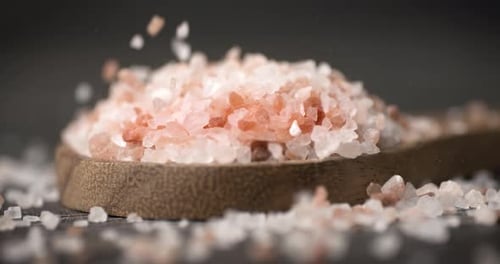Himalayan Pink Salt Falling onto Wooden Spoon