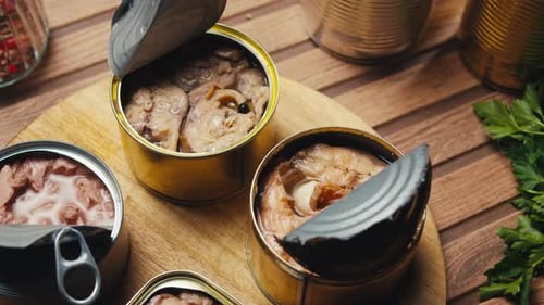 Opened Cans of Sardines and Tuna on Wooden Table