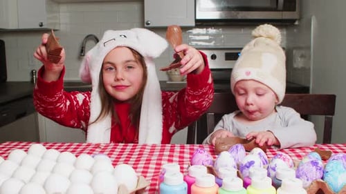 Crianças comem coelhinhos de chocolate na Páscoa
