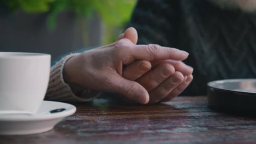 Unrecognizable Affectionate Senior Couple Holding Hands in Cafe