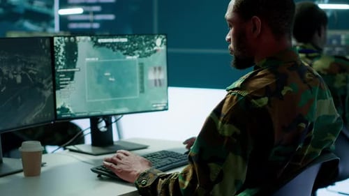 Military Personnel Monitoring Computer Screens in an Office