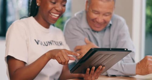 Volunteer Helping Senior Man with Tablet Technology