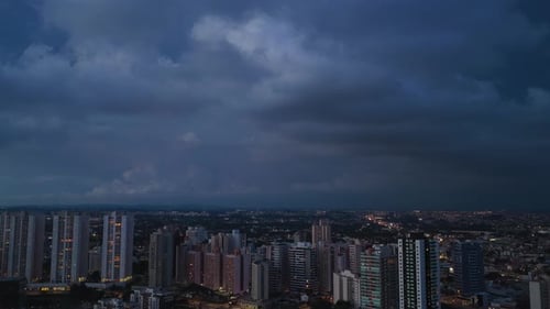 Aerial Cityscape Under Dark Storm Clouds at Night