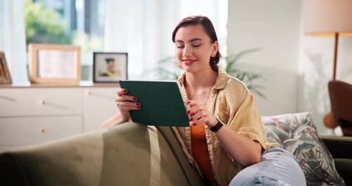 Woman Using Tablet on Couch in Living Room