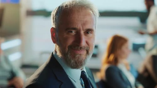 A close-up portrait of a smiling, confident businessman in a suit, exuding success.