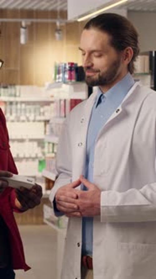 Hombres caucásicos africanos, farmacéutico, consulta con el cliente, el medicamento recomienda un síntoma de vitaminas saludables