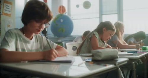 Elementary School Students Writing Exam or Doing Tasks in Notebooks