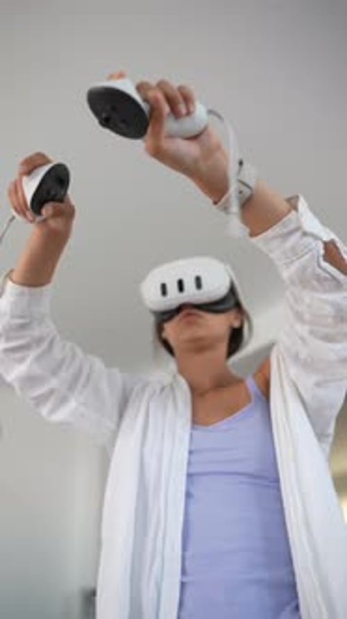 Person Using VR Headset with Hand Controllers